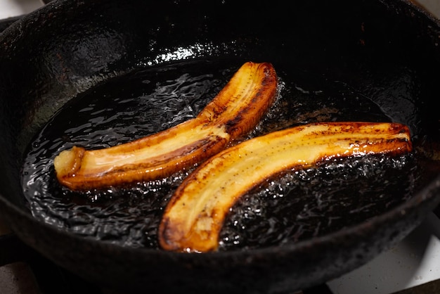 Banana frita na frigideira Banana crua cozida em óleo