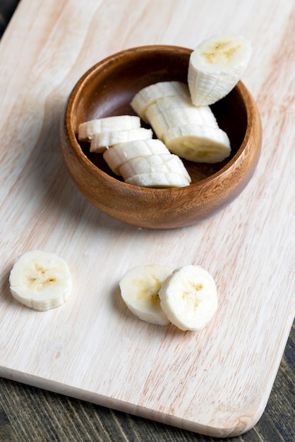 Banana madura fatiada em uma placa de madeira close-up