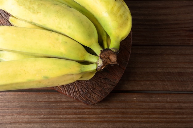 Banana madura isolada com fundo escuro de madeira.