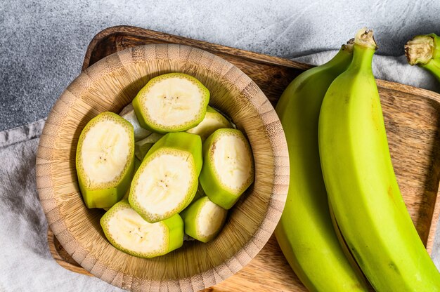 Banana verde cortada em uma tigela de madeira.