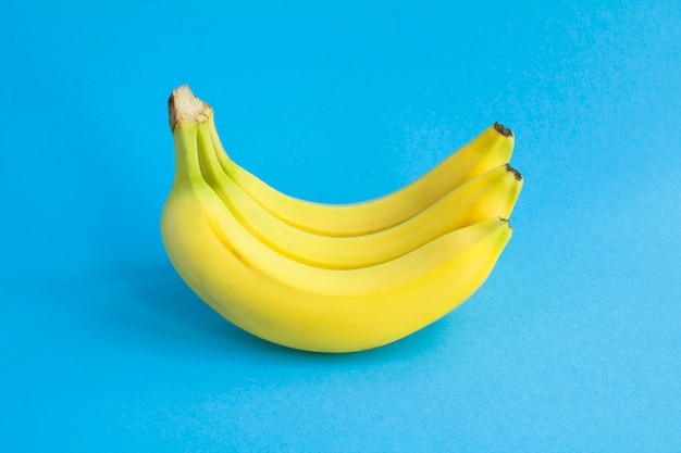 Bananas amarelas na superfície azul. fechar-se. superfície da fruta.