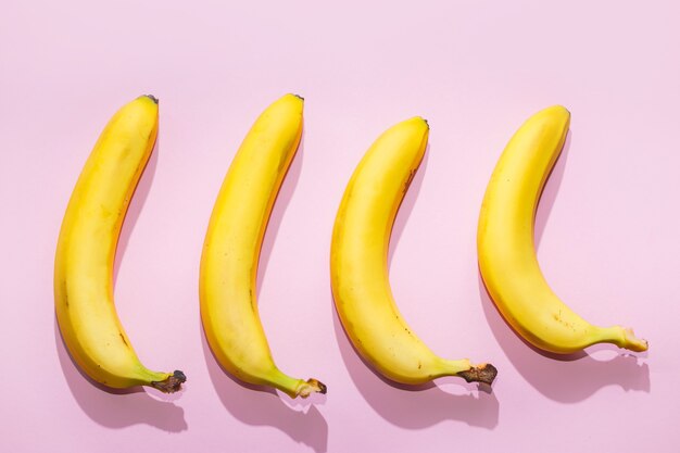 Bananas em fundo rosa pastel. conceito de comida ideia mínima