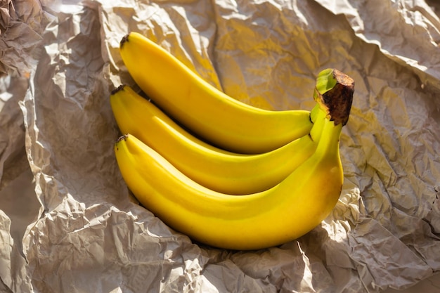 Bananas grandes amarelas em papel de pergaminho amassado Fundo de papel reciclado artesanal