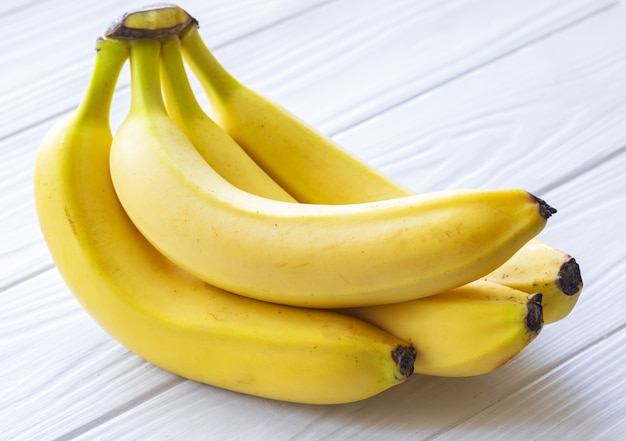 Bananas maduras em uma mesa de madeira branca