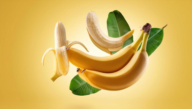 Foto bananas maduras y hojas que caen flotando sobre un fondo amarillo enteras y divididas en dos