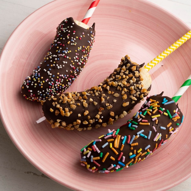 Bananas mergulhadas em chocolate amargo e cobertas com caramelo decorativo.