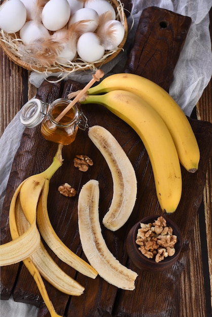Foto bananas, nozes, ovos, mel - ingredientes para assar pão de banana caseiro