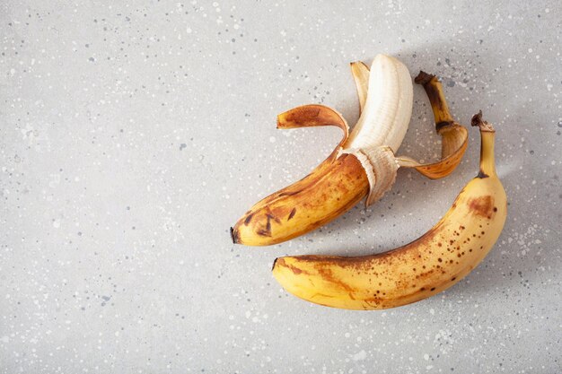 Foto bananas orgânicas maduras sobre fundo de concreto comida feia conceito de desperdício zero