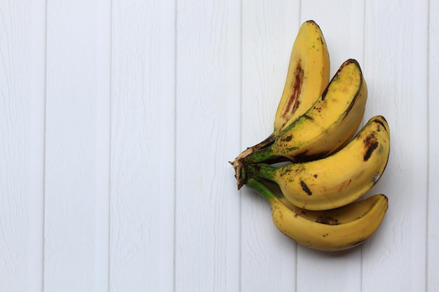 Bananas saba maduras no fundo branco meia composição