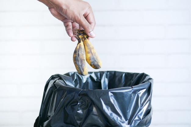 Banane in einen Mülleimer werfen