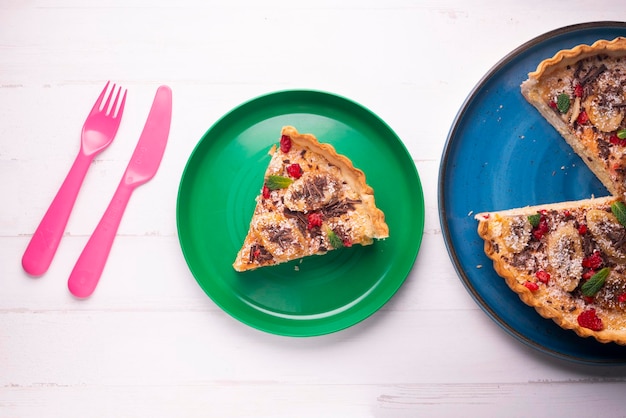 Bananen-Joghurt-Biskuitkuchen mit frischen Fruchtstückchen und Schokolade darauf