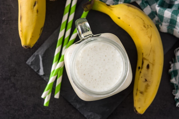 Bananen-Smoothie im Glas auf schwarzer Draufsicht