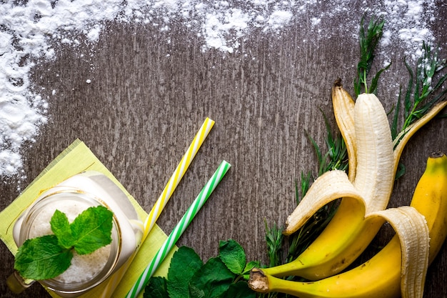 Foto bananen-smoothie und frische banane auf holztisch