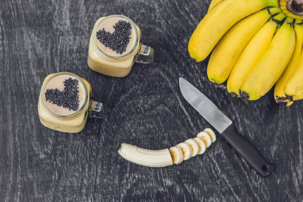 Bananen-Smoothies und Bananen auf einem alten hölzernen Hintergrund.