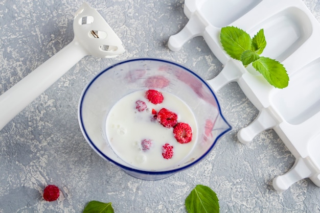 Foto bananen und himbeeren in plastikglasschüssel auf küchenoberfläche