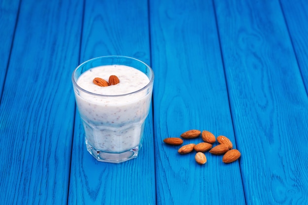 Bananen- und Mandelmilch Smoothie in einem Glas, blauer Hintergrund