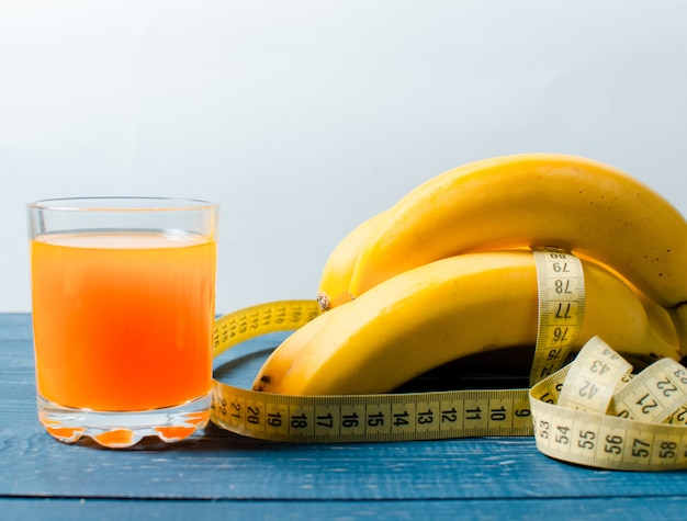 Bananen und Orangensaft auf einem hölzernen. Essen für Gewicht