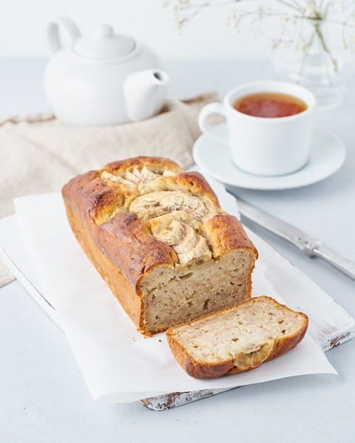 Bananenbrot, Kuchen mit Banane, Seitenansicht, vertikal. Der Morgen Frühstück mit Tee