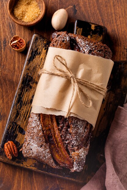 Bananenbrot mit Zimtcrunch und mit Puderzucker auf leichtem Betontisch bestreut.