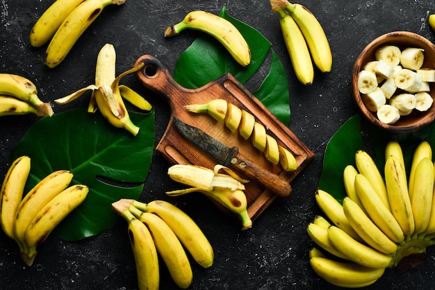 Bananenhintergrund Frische gelbe Babybananen auf einem Steintisch Draufsicht