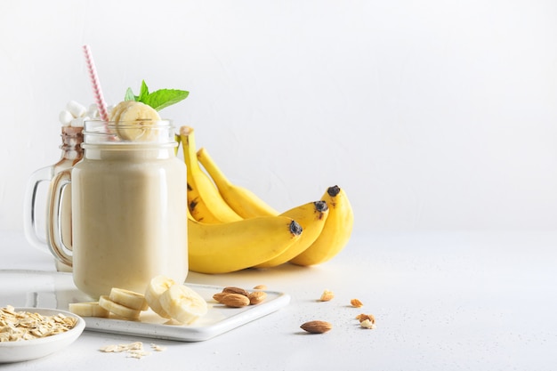 Bananenmilchshake auf weißer Tafel. Vertikales Format