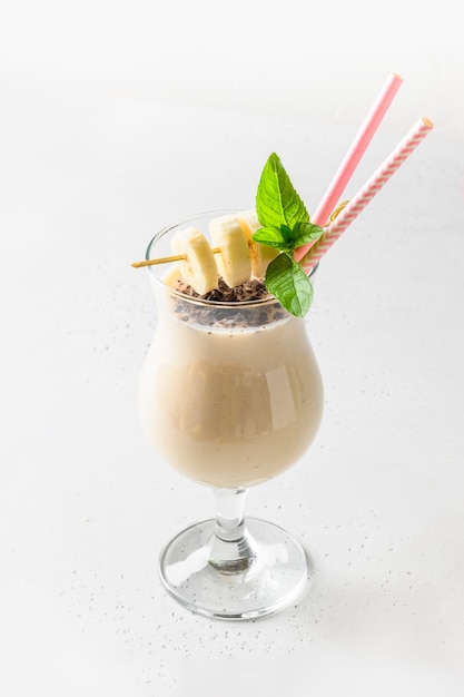 Bananenmilchshake im Cocktailglas lokalisiert auf Weiß.