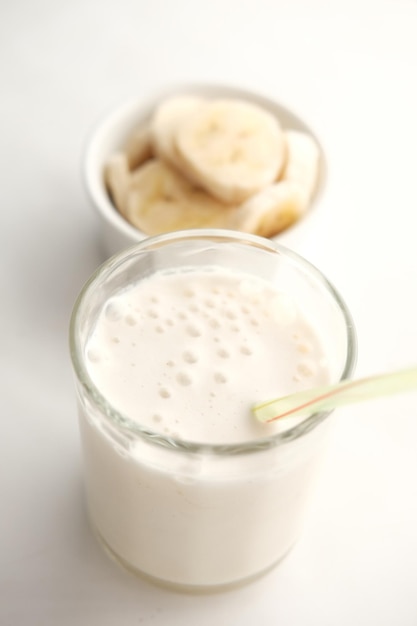 Bananenscheibe und Glas Milch auf dem Tisch