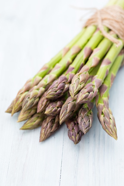 Banches von frischem grünem Spargel, Knoblauch, auf Betonoberfläche, Draufsicht