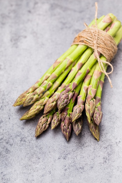 Banches von frischem grünem Spargel und Gemüse auf hölzernem Hintergrund, Draufsicht