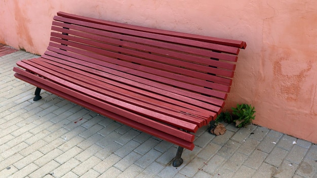 Banco confortável de madeira na cor vermelha da Borgonha, área de estar ao ar livre na rua