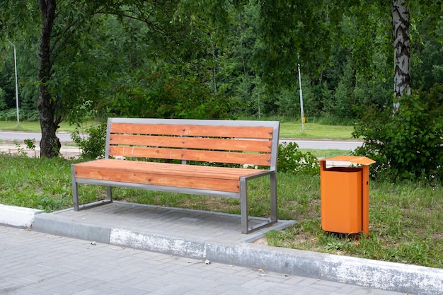 Banco de madeira e lata de lixo no parque