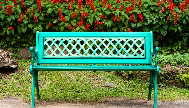 Banco de metal verde no parque. Relaxando com plantas e árvores