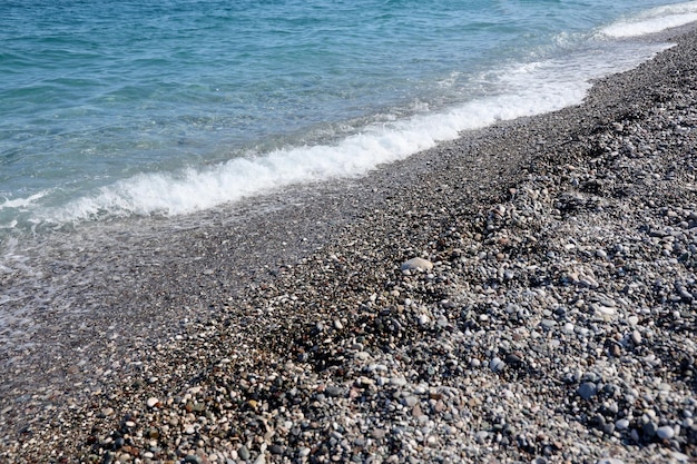 Banco de guijarros con el mar y la playa al fondo