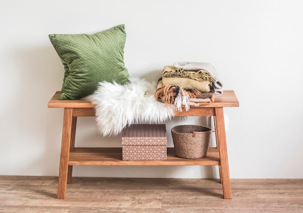 Banco de madera con una almohada a cuadros en una acogedora habitación de estilo escandinavo