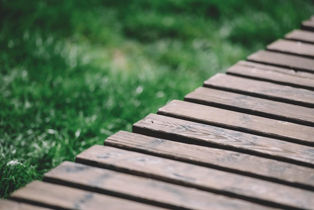 banco de madera en el jardín con un fondo de hierba verde