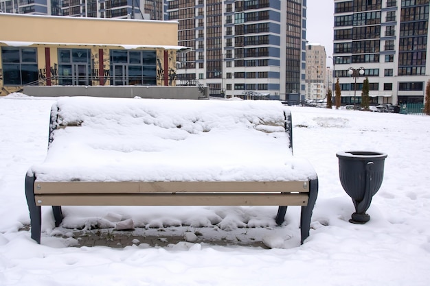 Banco de madera bajo la nieve en el parque