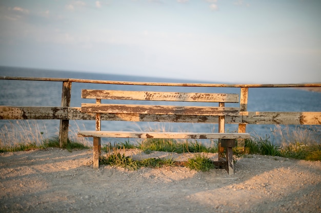 Banco de madera solitario junto al mar al atardecer