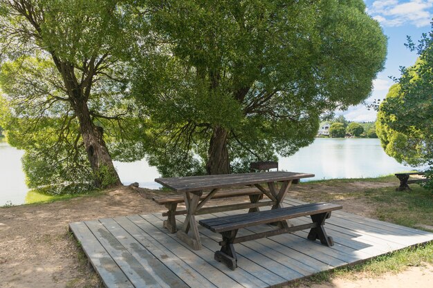 Banco de picnic vacío junto a la carretera junto al estanque. concepto de turismo