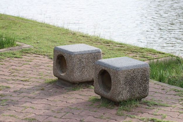 Banco de piedra al lado del lago en el parque.