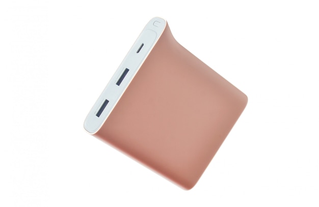 Banco del poder del rosa en colores pastel aislado en el fondo blanco. Batería externa para teléfonos inteligentes y otros dispositivos.