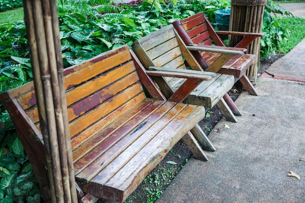 Banco y sillas de madera de diseño paisajístico arquitectónico cerca del jardín de hierba verde en público