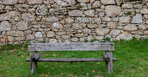 Foto banco vacío en el campo junto a la pared