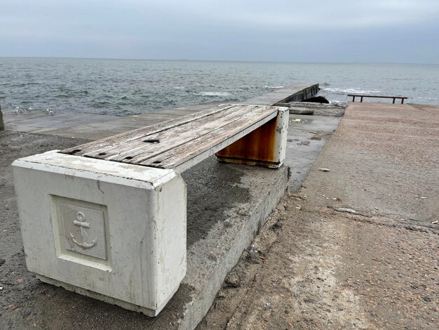 Banco vacío junto al mar bajo un espectacular cielo sombrío