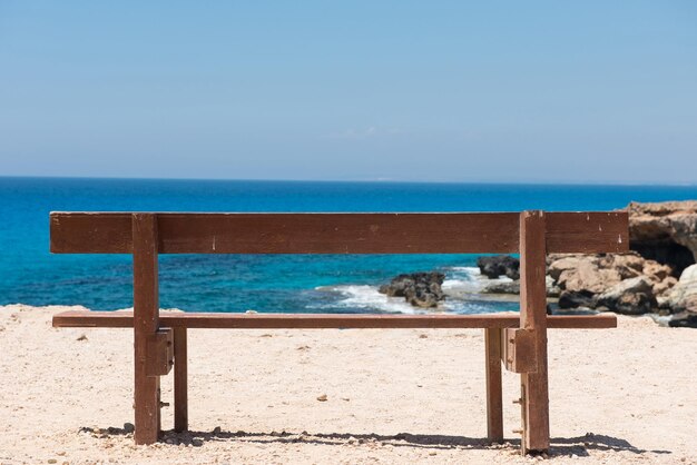 Un banco vacío de madera con una majestuosa vista al mar