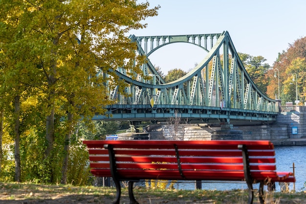 Foto banco vacío por el puente contra el cielo