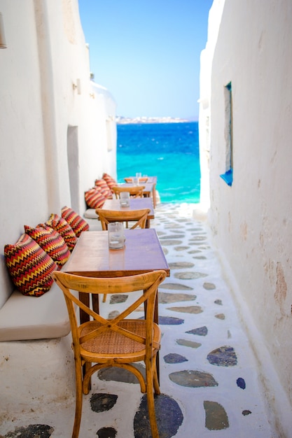 Bancos con almohadas en un típico bar griego en Mykonos con impresionantes vistas al mar en las islas Cícladas