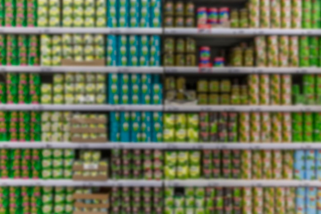 Foto bancos com comida enlatada nas prateleiras da loja ervilhas verdes e legumes em latas de ferro vista frontal desfocada