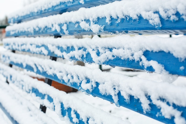 Los bancos para descansar están cubiertos de nieve en el parque en invierno.