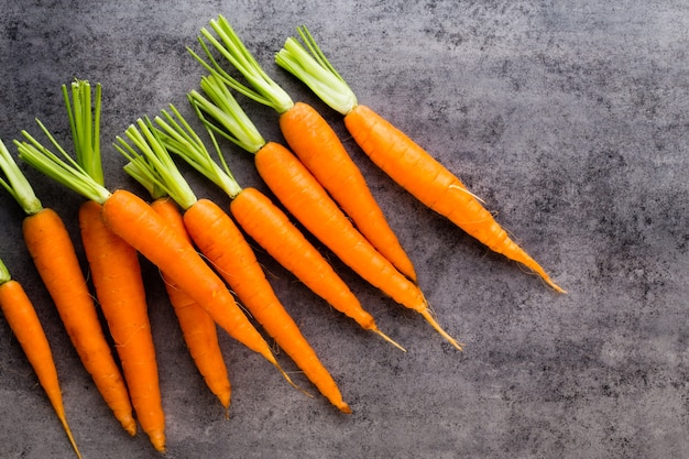 Bancos de espárragos verdes frescos y verduras sobre superficie de hormigón, vista superior