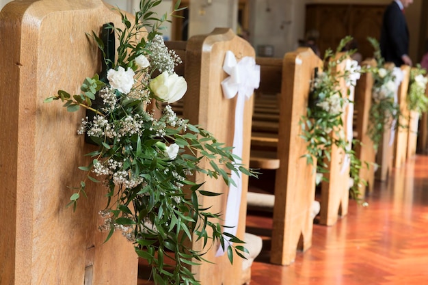 Bancos de iglesia decorados con flores en una ceremonia de boda